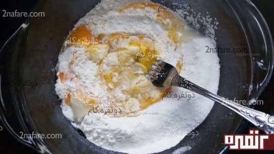 اضافه کردن تخم مرغ به مواد خشک برای تهیه کیک فنجونی