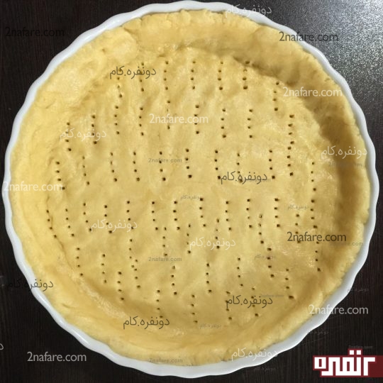 پهن کردن خمیر کف قالب و سوراخ کردن باچنگال