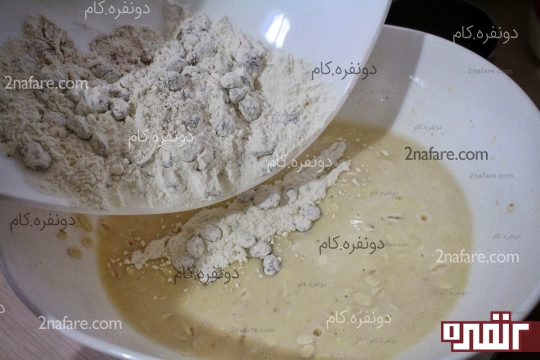 افزودن مخلوط آردی و کشمش به مخلوط تخم مرغ و اوتمیل