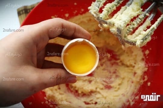 اضافه کردن زرده تخم مرغ به مخلوط کره و شکر
