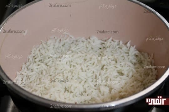 ریختن یک لایه برنج کف قابلمه