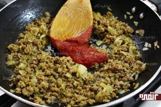 اضافه کردن رب گوجه فرنگی به کوشت و پیاز تفت داده شده