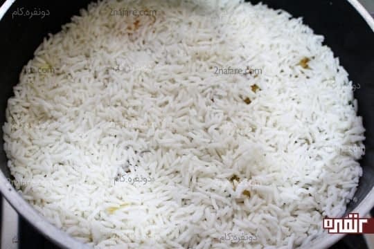 ریختن مابقی برنج آبکش شده روی بادمجان ها