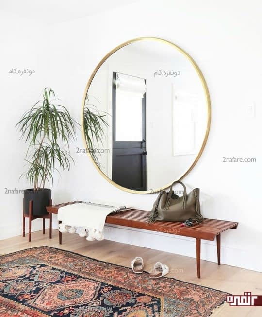 آینه با قابی طلایی و پس زمینه ی خنثی