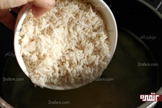 اضافه کردن برنج در آب در حال جوش