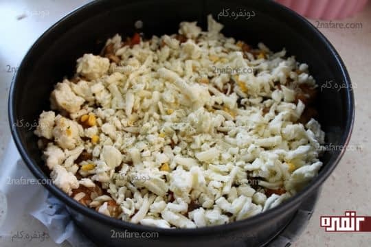 ریختن پنیر موزارلا رنده شده به همراه پودر اورگانو