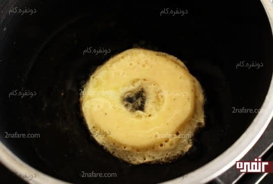 سرخ کردن سیب آغشته شده به خمیر در حمام روغن داغ