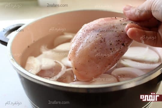 قرار دادن مرغ های مزه دار شده در آب و پیاز در حال جوشیدن
