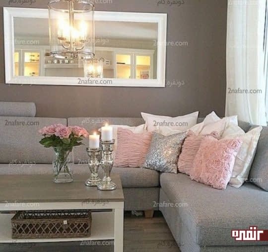 کوسن های صورتی رنگ در کنار مبلمان خاکستری