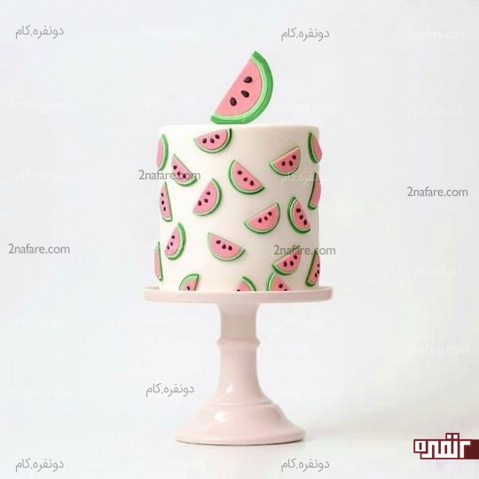 کیک پوشیده شده با فوندانت سفید و تزیین شده با برش های هندوانه فوندانتی