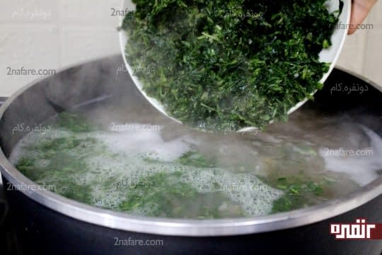 اضافه کردن سبزی آش به حبوبات در حال جوشیدن