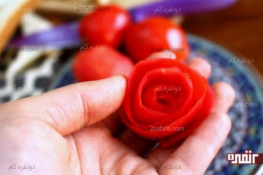 رول کردن پوست گوجه به صورت گل رز