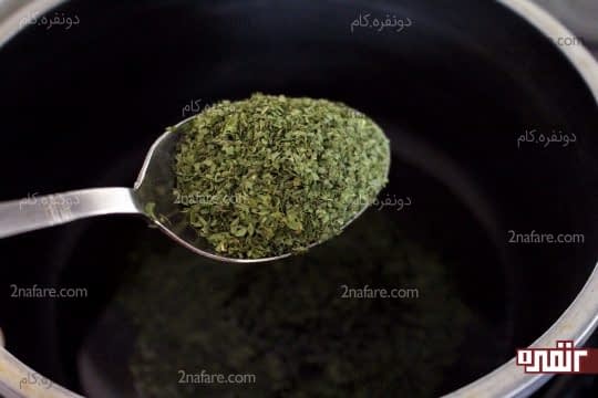 ریختن پودر نعنا خشک داخل روغن در حال داغ شدن