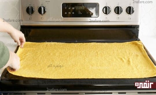 پهن کردن حوله روی سطح اجاق