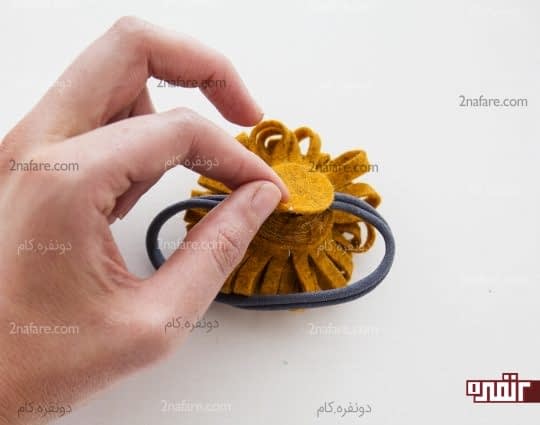 چسباندن گل به هدبند به کمک یک تکه نمدی دایره شکل