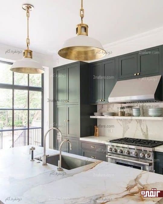 آشپزخانه ای با لوازم استیل و لوسترهای طلایی رنگ