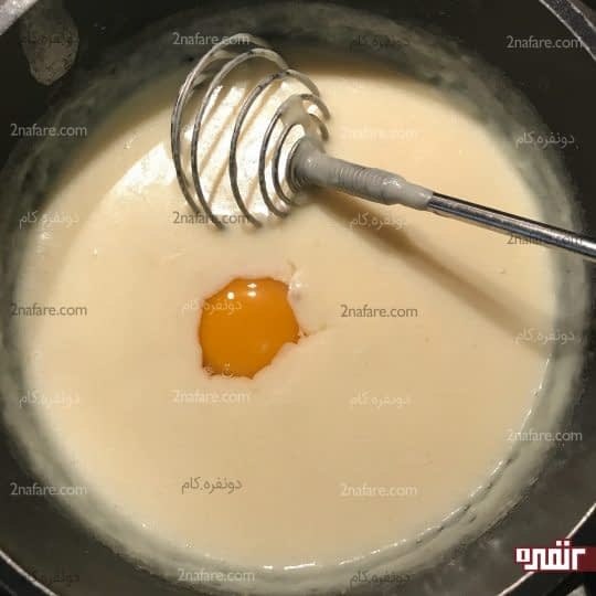 اضافه کردن اولین تخم مرغ به سس سفید