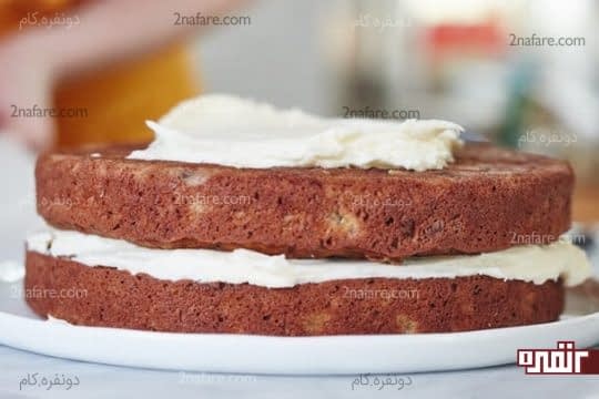 قرار دادن دو لایه کیک روی هم و پوشاندن آنها با کرم پنیری