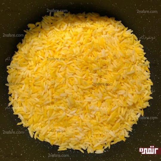 ریختن مقداری از برنج در قابلمه